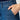 Close-up of blue jeans with a hand in the pocket against a neutral background